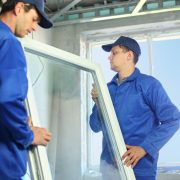 Two workers putting in new window