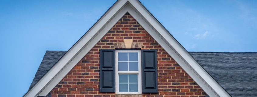 A closeup of a double-hung window on a red brick house